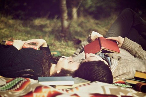 couple couché dans la forêt avec livres
