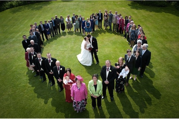photo de groupe en coeur avec mariés au milieu